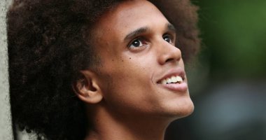 Contemplative happy young african man candid