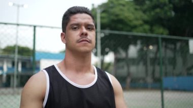 Ciddi bir ifadeyle spor giyimli İspanyol bir Güney Amerikalı gencin portresi.