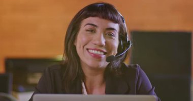 Kameraya gülümseyen kulaklık takan İspanyol genç bir kadının portresi. Güney Amerikalı kadın çalışan çağrı merkezi desteğinde