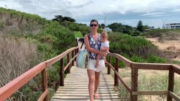 Mor Håller Baby Promenader Mot Stranden Havet Träväg — Stockvideo