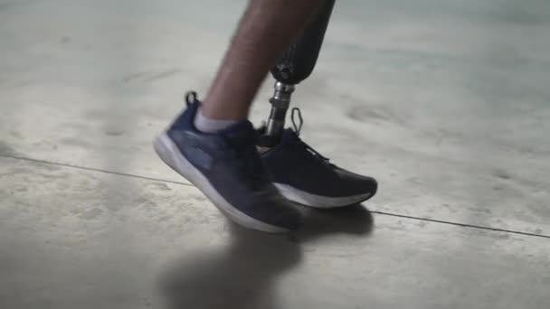 義足で屋内を歩く障害者 切断者男あります歩くとともに義足 — ストック動画