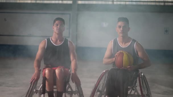 Два Інвалідні Спортсмени Інвалідних Кріслах Дивляться Камеру Яка Тримає Баскетбольний — стокове відео