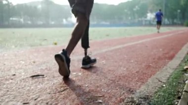 Disabled athlete with prosthetic leg running in slow motion. Determination concept