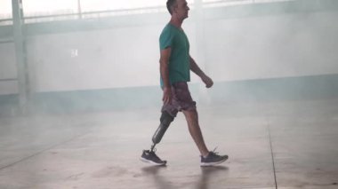 Orta yaşlı sakat bir adam protez bacağı içeride yürüyor.