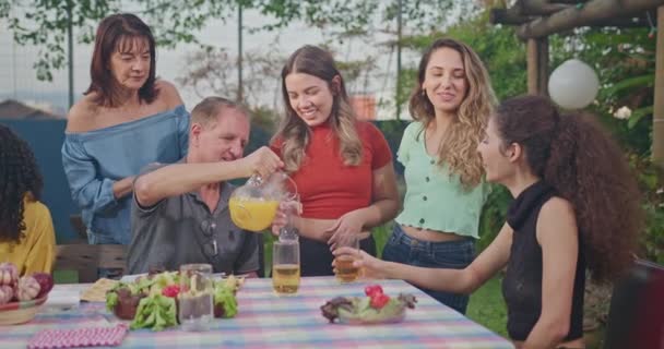 Группа Друзей Болтает Барбекю Заднем Дворе Смеются Счастливы Сидя Столом — стоковое видео