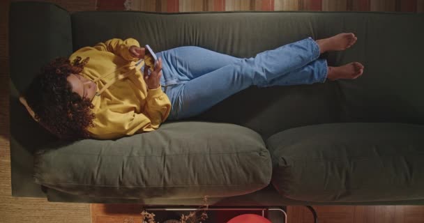 Young Woman Sits Sofa Her Living Room Picks Her Cell — Stock Video