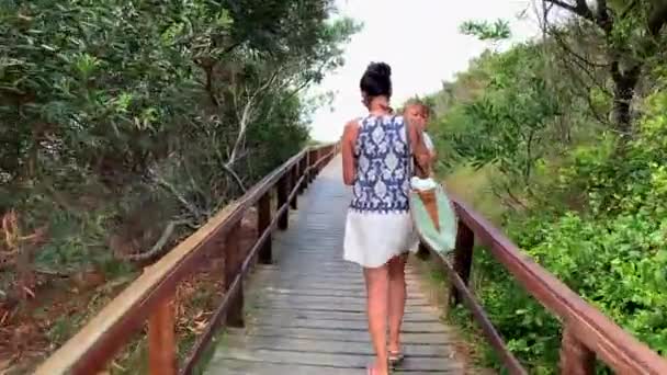 在通往海滩的木制小径上行走的妇女和婴儿 — 图库视频影像