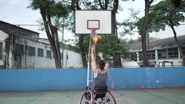 障害者アスリート得点はバスケットボールネット内でボールを投げる 車いすスコアでの障害者トレーニング — ストック動画