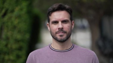 Dışarıdaki kameraya doğru yürüyen mutlu, motive edici bir yakışıklı. Gülümseyen erkek sokakta yürüyor