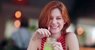 Elinde sağlıklı bir detoks içeceği tutarken kameraya gülümseyen kızın portresi