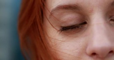 Derin düşüncelere dalmış, gözleri kapalı genç bir kadın. Rüzgarın estiğini ve derin düşüncelere daldığını hissediyor..