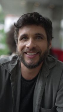 Kameraya yakından gülümseyen genç bir adamın portresi. Dikey Videoda Mutlu 30 'lu yıllar