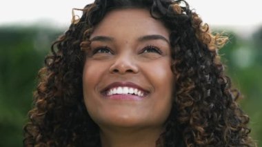 Umut dolu bir Brezilyalı siyahi kız UMUT ve FAITH ile kameraya bakıyor. Ruhani Afrikalı Amerikalı yetişkin bir kızın yakın çekim yüzü.