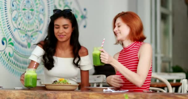 Dos Mujeres Jóvenes Bebiendo Jugo Verde — Vídeos de Stock
