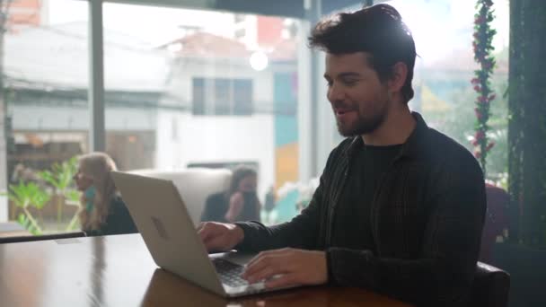 カフェレストランでノートパソコンの前で起業家 現代の技術を使って遠隔操作する若者 — ストック動画