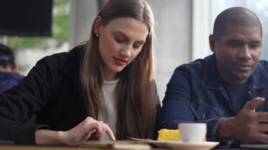 Kahve dükkanında telefon kullanan genç bir kadın. Kafe restoranında cep telefonlarına bakan iki kişi. Teknolojik baloncuklarındaki çift