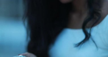 Siyah Afrikalı kız dışarıda cep telefonu ekranına bakıyor.