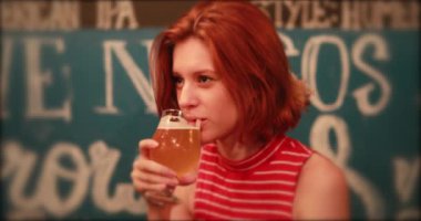 Kızıl saçlı genç milenyum kadını gece bira içiyor..