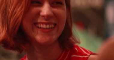 Kızıl saçlı güzel kadın gece bir yudum bira içiyor, samimi ve sıradan..