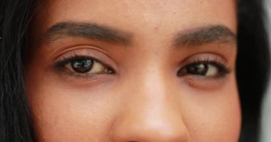 Afrikalı kız gözleri ve yüzü kameraya bakıp gülümsüyor