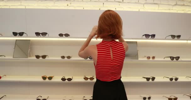 Jovem Mulher Ruiva Bonita Tentando Óculos Sol Compras — Vídeo de Stock