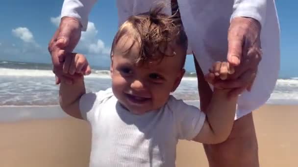 Lindo Bebé Playa Padres Apoyando Bebé Orilla Ayudando Explorar — Vídeos de Stock