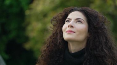 Gökyüzüne bakan düşünceli kadın yüzü. Dikkatli bir kadın. Meditasyoncu insan doğada ayakta durmayı umuyor.