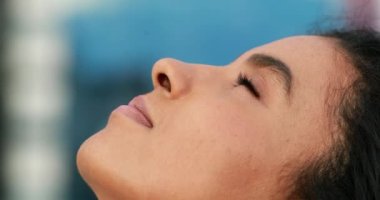 Genç siyah Afrikalı kadın gökyüzüne doğru bakıyor. Gözlerini açıyor..