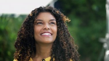 Umut dolu genç bir kadın FAITH ile gökyüzüne bakıyor. Mutlu bir Afro-Amerikalı dışarıda dikilirken yüzünü kapatıyor.