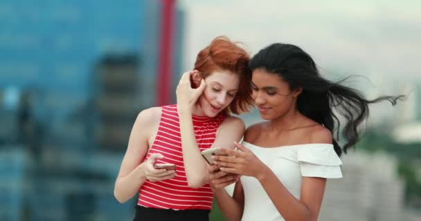 Две Молодые Многорасовые Женщины Смотрят Экран Мобильного Телефона — стоковое видео