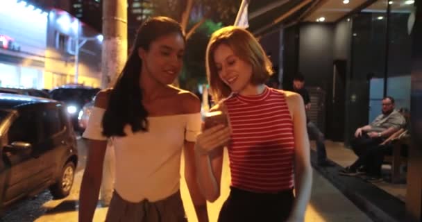 Two Multiracial Female Friends Walking City Showing Cellphone Screen — Stock Video