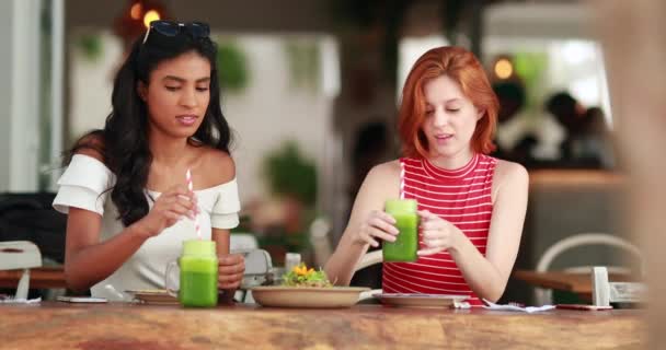Dos Chicas Bonitas Diversas Bebiendo Jugo Verde Mujeres Jóvenes Multiculturales — Vídeos de Stock