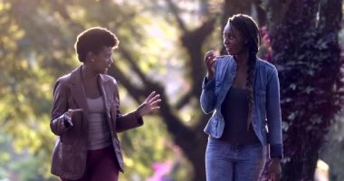 Dışarıda sokakta gülen ve gülümseyen iki kadın. Arkadaş şaşırmaya tepki veriyor