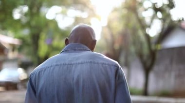 Düşünceli kel Afrikalı adam, dışarıda duran düşünceli kişinin arkası.