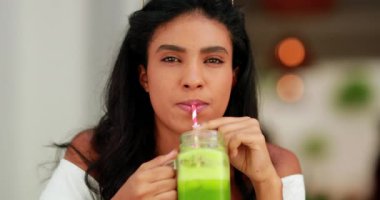 Yeşil meyve suyu içen genç bir kadın