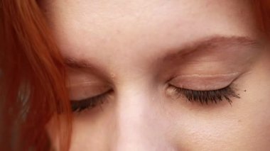 Yeşil gözlü, güzel kızıl saçlı kadının yakın çekimi.