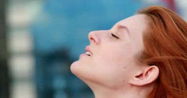 Gökyüzüne inançla bakan genç bir kadın yüzü