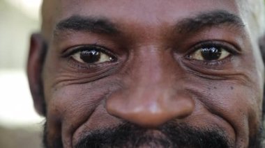 Afrikalı adam kameraya gülümsüyor. Yakın çekim makro gözler sırıtıyor.