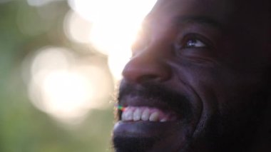 Afrikalı bir adam mercekli güneş ışığını düşünerek dışarıda gözlerini açıyor.