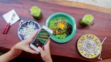 Kız elleri yemek tabağının fotoğrafını çekiyor.