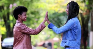 Dışarıda el ele tutuşan iki Afrikalı kadın.