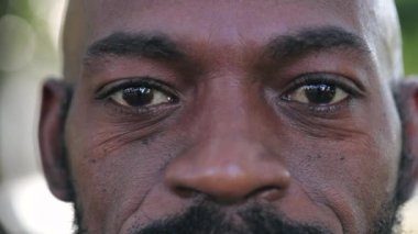 Mutlu Afrikalı adam gülümseyen makro yakından bakan gözler, orta yaşlı siyah adam.