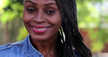 Kendinden emin Afrikalı kadın gülümsüyor, portresi siyah.