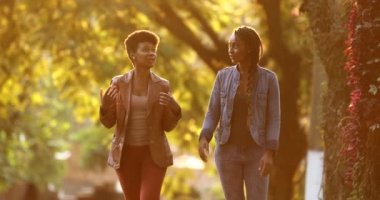 Sokağın ortasında gün ışığıyla konuşan iki kadın.