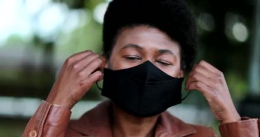 Siyah maske takan Afrikalı bir kadın.