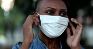 Siyahi kadın salgının sona ermesini kutlayan siyah maskesini çıkarıyor.