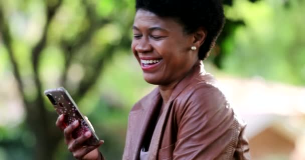 Glückliche Afrikanerin Feiert Benachrichtigung Auf Handy Gerät Draußen — Stockvideo