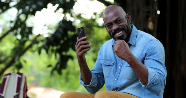 Afrikai Férfi Ünnepli Teljesítményét Mobiltelefon — Stock videók