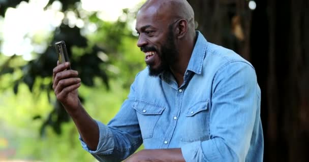 Leende Glad Afrikansk Man Som Håller Smartphone Glada Känslor — Stockvideo