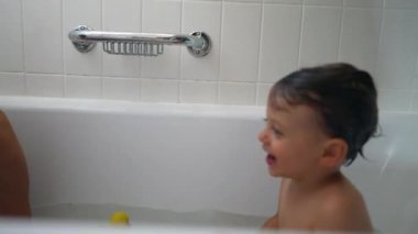 Çocukları içeride yıkıyorlar. Küçük kardeşle banyo yapan genç bir çocuk.